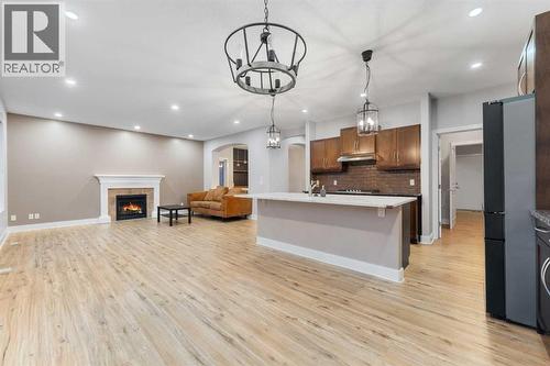 The kitchen features quartz countertops, stainless steel appliances, and a gas cooktop. - 70 Royal Ridge Manor Nw, Calgary, AB - Indoor Photo Showing Kitchen With Fireplace