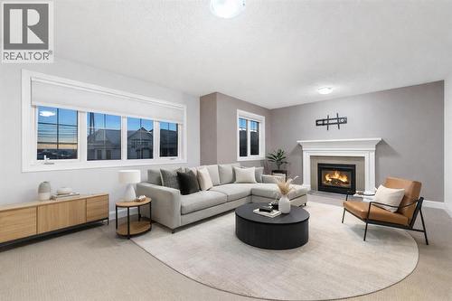 Spacious bonus room featuring a fireplace and views of the downtown skyline  Generously sized bonus room with a fireplace and downtown skyline views (Virtually Staged). - 70 Royal Ridge Manor Nw, Calgary, AB - Indoor Photo Showing Living Room With Fireplace