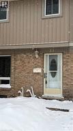 Snow covered property entrance featuring brick siding - 