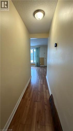 Hallway with dark wood-style floors and a textured ceiling - 66 Glamis Road Unit# 33, Cambridge, ON - Indoor Photo Showing Other Room