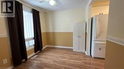 Kitchen with freestanding refrigerator, light wood finished floors, ceiling fan, and a textured ceiling - 