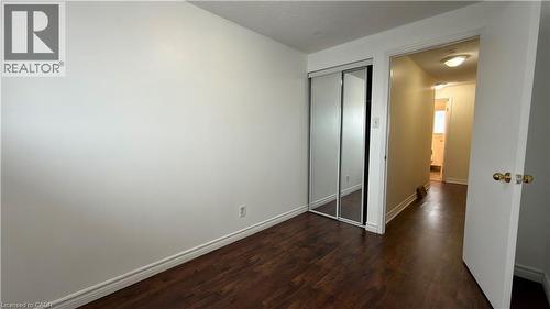 Unfurnished bedroom featuring dark wood-style flooring and a closet - 66 Glamis Road Unit# 33, Cambridge, ON - Indoor Photo Showing Other Room