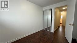 Unfurnished bedroom featuring dark wood-style flooring and a closet - 