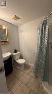 Bathroom featuring a shower with shower curtain, vanity, and light tile patterned floors - 