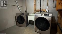 Laundry area featuring washing machine and dryer and unfinished concrete flooring - 
