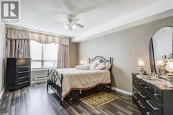Bedroom with baseboards, a textured wall, dark wood-style flooring, baseboard heating, and a textured ceiling - 