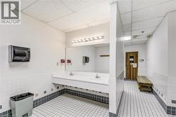 Bathroom featuring a sink, tile patterned flooring, a paneled ceiling, and tile walls - 