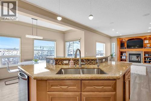 100 Cougarstone Manor Sw, Calgary, AB - Indoor Photo Showing Kitchen With Fireplace With Double Sink