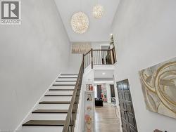 Stairs featuring a towering ceiling, a chandelier, and wood finished floors - 