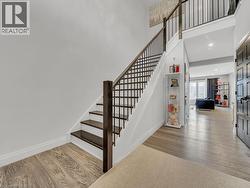 Stairway with wood finished floors, a towering ceiling, and recessed lighting - 