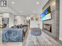 Living room with light wood-type flooring, a fireplace, and recessed lighting - 
