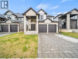 View of front facade with a front yard, driveway, a garage, and brick siding - 