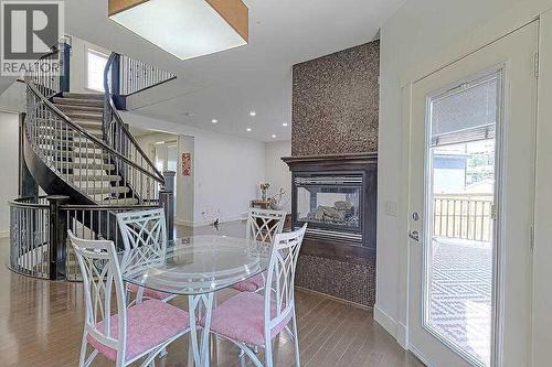 16 Rockcliff Point Nw, Calgary, AB - Indoor Photo Showing Dining Room With Fireplace