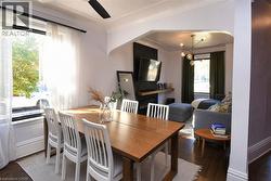 Dining area featuring dark wood-style floors, arched walkways, a ceiling fan, and a chandelier - 