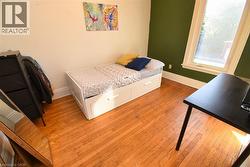 Bedroom with light wood-style flooring and baseboards - 