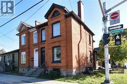 View of front facade featuring a chimney and brick siding - 