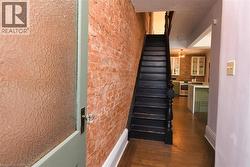 Staircase featuring brick wall and wood finished floors - 