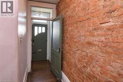 Doorway with brick wall and wood finished floors - 