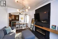 Living room with a high end fireplace, arched walkways, and dark wood-type flooring - 