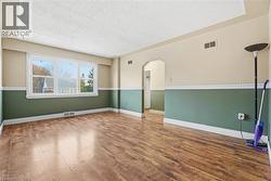 Living room with arched walkways, wood finished floors, and a textured ceiling - 
