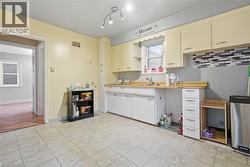 Kitchen with light countertops, open shelves, and cream cabinetry - 