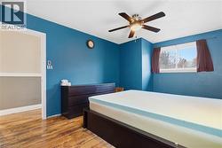 Bedroom with light wood-style flooring and a ceiling fan - 