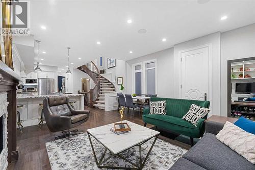 The main level impresses with wide plank engineered oak hardwood, built-in speakers and striking finish detail throughout - 922 5 Street Nw, Calgary, AB - Indoor Photo Showing Living Room