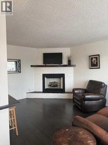 202, 11114 Hoppe, Grande Cache, AB - Indoor Photo Showing Living Room With Fireplace