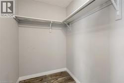 Walk in closet with dark wood finished floors - 