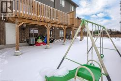 Snow covered patio featuring a playground and a deck - 