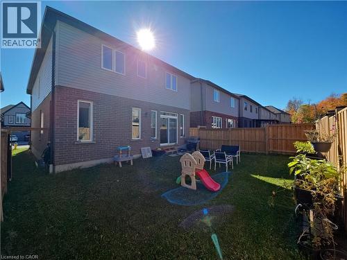 Rear view of house with brick siding and a fenced backyard - 293 Chokecherry Crescent, Waterloo, ON - Outdoor With Exterior