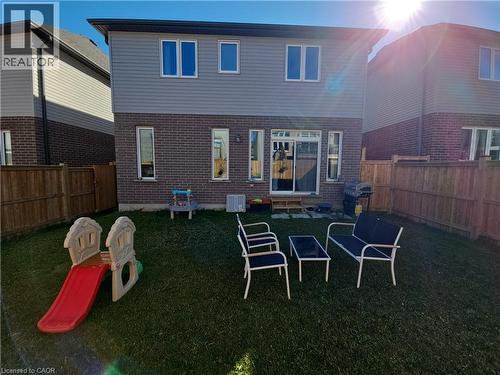 Back of house with a fenced backyard, brick siding, and entry steps - 293 Chokecherry Crescent, Waterloo, ON - Outdoor With Exterior