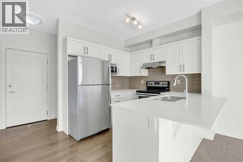 211, 10 Walgrove Walk Se, Calgary, AB - Indoor Photo Showing Kitchen With Stainless Steel Kitchen With Double Sink With Upgraded Kitchen