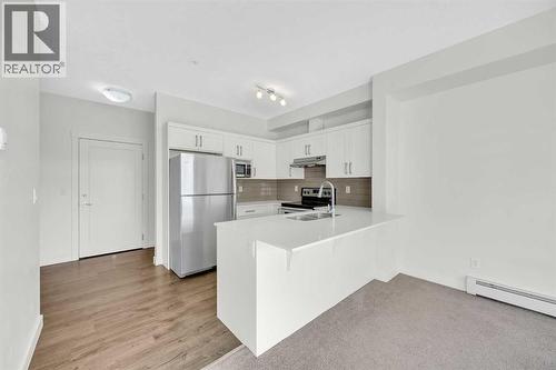 211, 10 Walgrove Walk Se, Calgary, AB - Indoor Photo Showing Kitchen With Stainless Steel Kitchen With Double Sink