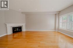 Unfurnished living room with light wood-type flooring, a fireplace, recessed lighting, and baseboards - 