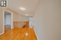 Corridor with an upstairs landing, light wood finished floors, and baseboards - 
