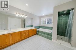 Full bath with a garden tub, double vanity, tiled shower, and tile patterned floors - 