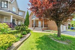 View of front facade featuring brick siding, a front lawn, a porch, and a garage - 