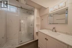 Full bathroom featuring vanity and a marble finish shower - 