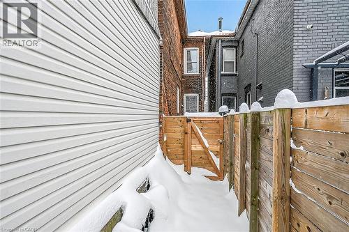 View of property exterior with brick siding and a gate - 77 Barton Street E Unit# 1, Hamilton, ON - Outdoor