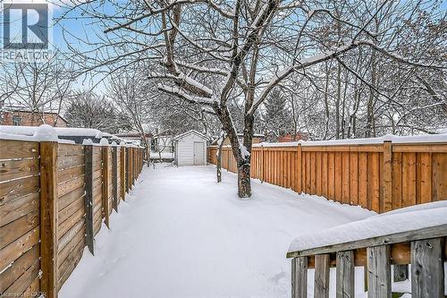 Yard covered in snow with a fenced backyard and a shed - 77 Barton Street E Unit# 1, Hamilton, ON - Outdoor