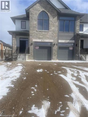 View of front facade with stone siding, an attached garage, and driveway - 152 Queensbrook Crescent, Cambridge, ON - Outdoor With Facade
