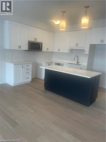 Kitchen with dark cabinetry, white cabinetry, and pendant lighting - 152 Queensbrook Crescent, Cambridge, ON - Indoor Photo Showing Kitchen