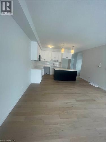 Kitchen with decorative backsplash, light countertops, open floor plan, a center island, and light wood-style floors - 152 Queensbrook Crescent, Cambridge, ON - Indoor Photo Showing Other Room