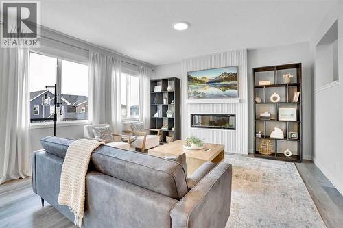 86 Edith Row Nw, Calgary, AB - Indoor Photo Showing Living Room With Fireplace