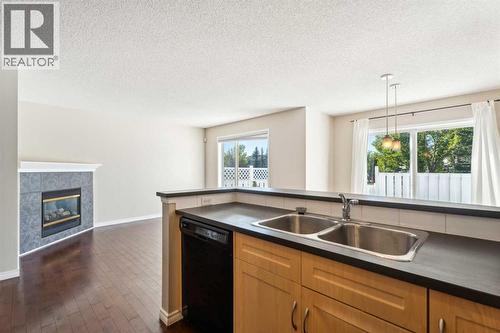 73 Rocky Ridge Heath Nw, Calgary, AB - Indoor Photo Showing Kitchen With Fireplace With Double Sink