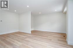 Empty room with light wood-style floors and recessed lighting - 