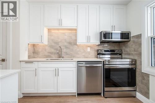 Kitchen featuring stainless steel appliances, white cabinetry, and light stone countertops - 27 Queenston Drive, Kitchener, ON - Indoor Photo Showing Kitchen With Stainless Steel Kitchen With Upgraded Kitchen