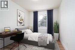 Bedroom featuring wood finished floors and a desk - 