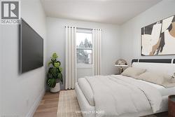 Bedroom featuring wood finished floors and baseboards - 